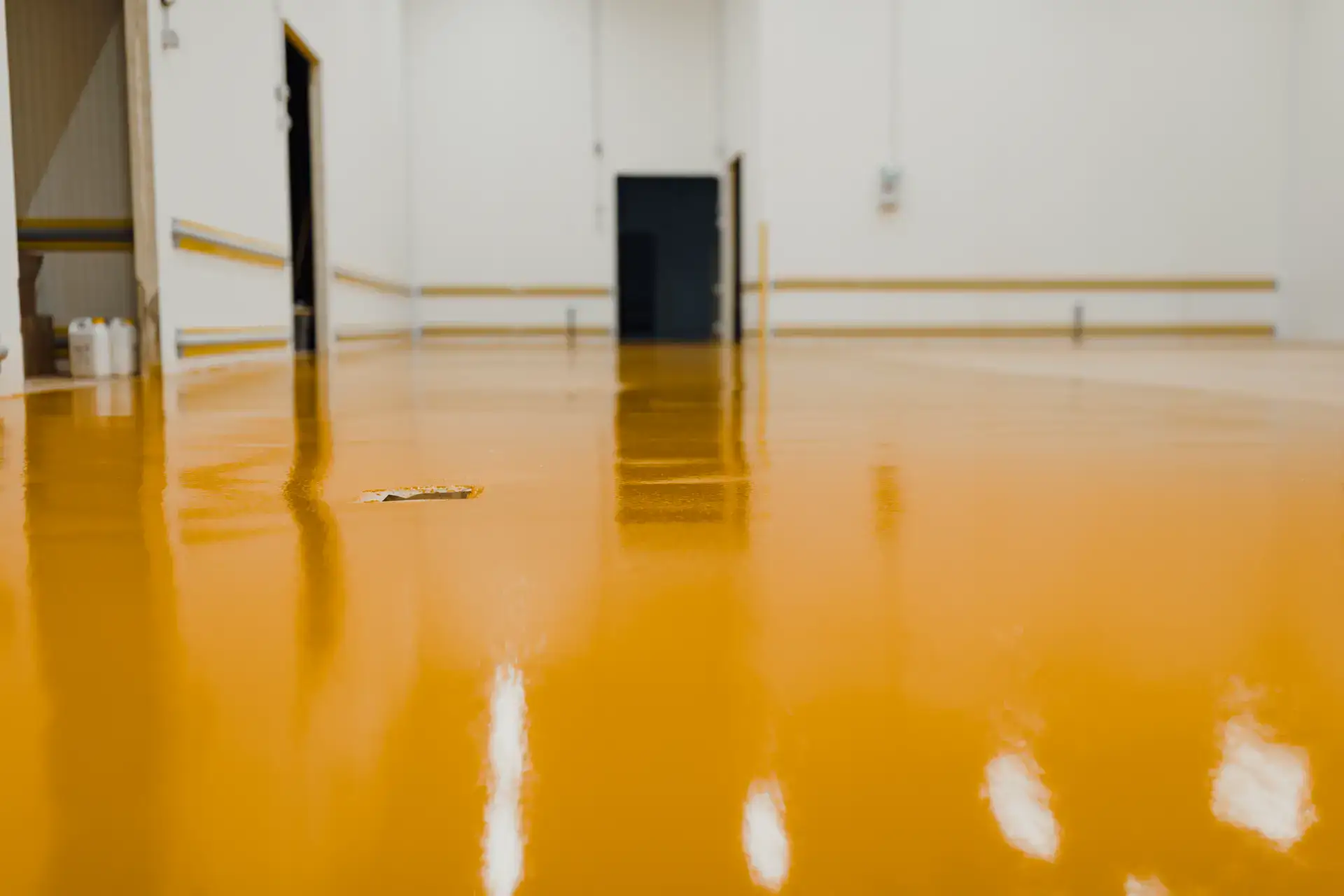 Nyrenoveret industrilokale med blankt, orange-lakeret gulv.